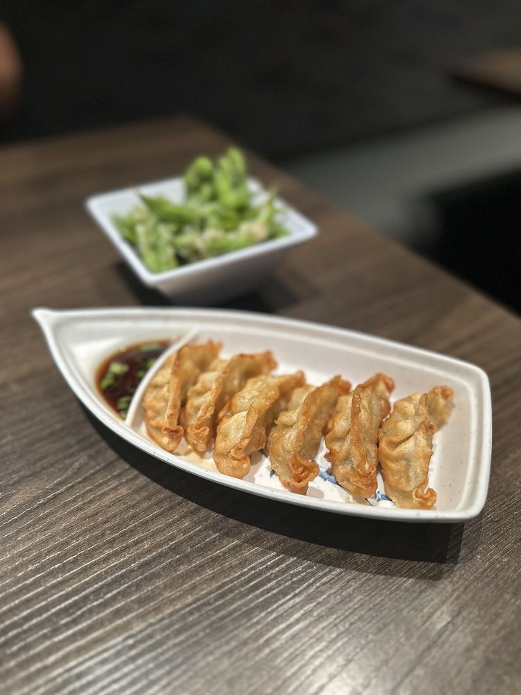 Crispy gyoza with dipping sauce and a bowl of edamame